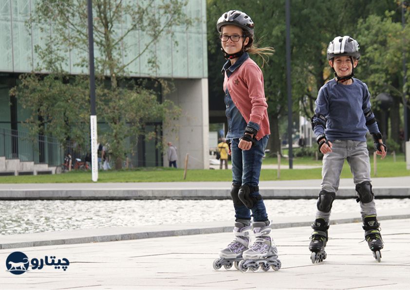 یک پسر بچه و یک دختر بچه اسکیت برند رولربلید را پوشیده اند در پارک مشغول بازی
